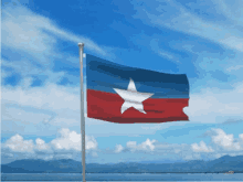 a flag with a white star on it is flying in the wind