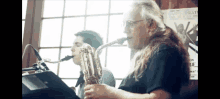 a man playing a saxophone in front of a window with a poster that says ' theatre ' on it