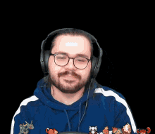 a man with a beard wearing headphones and a blue and white sweatshirt