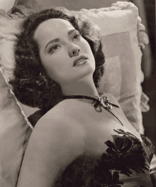 a black and white photo of a woman laying on a pillow