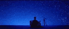 a person is sitting under a starry sky .