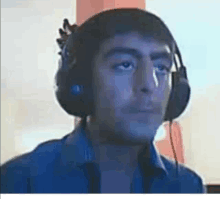 a man wearing headphones is looking at the camera and making a funny face .