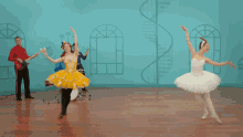 a group of ballerinas are dancing in front of a blue wall