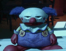 a stuffed toy clown is sitting on a table .