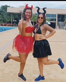 two women dressed in devil costumes pose for a photo