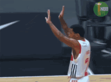 two basketball players give each other a high five with a nbr logo in the background