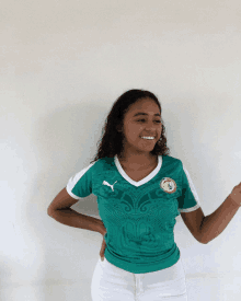 a woman wearing a green shirt with a soccer team logo on it