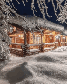 a log cabin covered in snow at night