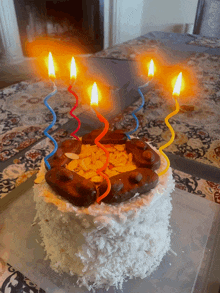 a birthday cake with four lit candles on top of it