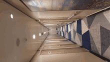 a very long hallway with a blue and white carpet