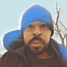 a man with a beard wears a blue beanie