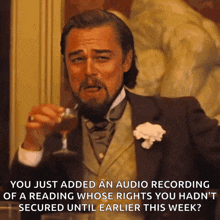 a man in a suit is holding a glass of wine with a caption that says you just added an audio recording