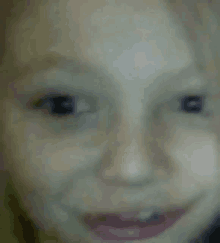 a close up of a child 's face with a smile .