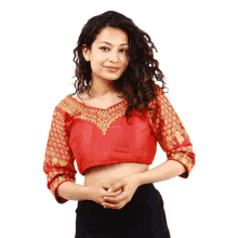 a woman wearing a red blouse with gold embroidery on the sleeves