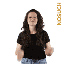 a woman in a black shirt is making a gesture with her hands in front of a white background that says no such