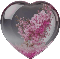 a heart shaped glass container with pink flowers in it