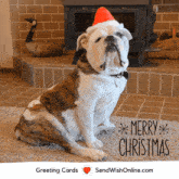 a bulldog wearing a santa hat is sitting in front of a fireplace with a greeting card that says merry christmas