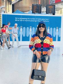 a woman standing in front of a sign that says we 're increasing the number of ticket gates