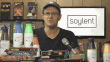 a man stands in front of a soylent logo