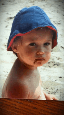 a baby wearing a blue hat is sitting on a table