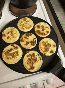 pancakes are cooking in a frying pan on the stove