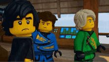 a group of lego figures standing next to each other with one wearing a black shirt with a dragon on it