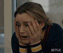 a woman covering her face with her hands and a netflix logo in the corner