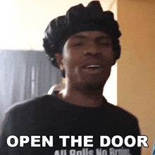 a man wearing a black hat and a black shirt says open the door