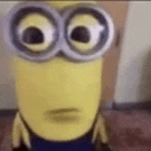 a close up of a minion wearing glasses and making a face .