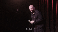 a bald man singing into a microphone with the words oh god below him