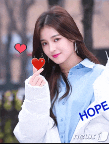 a woman wearing a white jacket that says hope on it