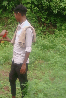 a man with a towel around his neck is standing in a grassy field