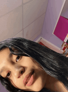 a girl with long black hair is taking a selfie in a purple room