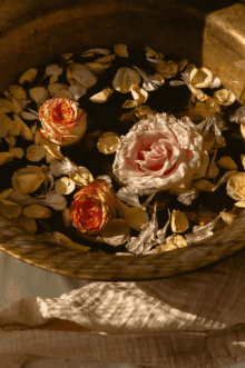 a bowl filled with water and petals with roses in it