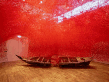 two boats are sitting in a room with a red wall