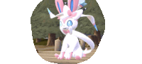 a white and pink pokemon with a bow on its head is sitting on a wooden surface .