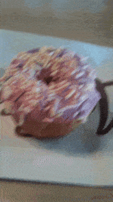 a donut with pink frosting and sprinkles on top