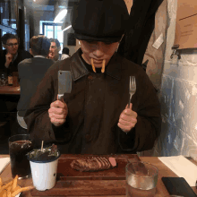 a man eating a steak with a knife and fork in his mouth