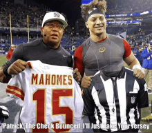 a man holding a mahomes jersey next to another man