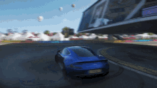 a blue car with a yellow license plate is driving down a track