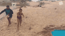 a woman in a bathing suit is running on a sandy beach with the words jukin viral as in the background