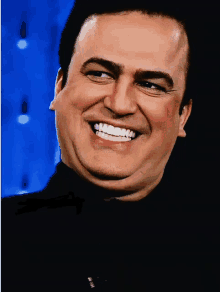 a man in a black shirt is smiling with a blue background