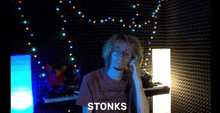 a man talking on a phone with the word stonks written below him