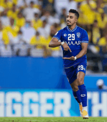 a soccer player with the number 29 on his jersey is running on the field