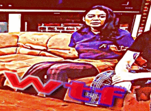 a woman sits on a couch with a wtf logo on the floor