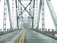 a bridge with a white background and yellow lines on the road