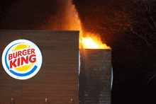 a burger king sign is lit up in the dark