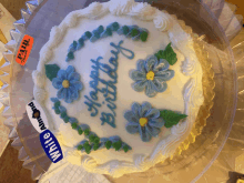 a white cake with blue flowers and the words happy birthday written on it