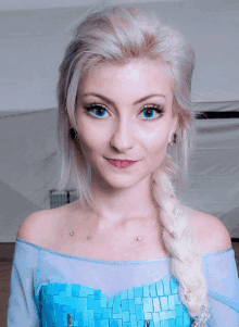 a woman with blonde hair and blue eyes is dressed as elsa