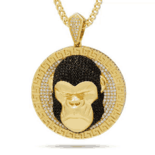 a gold pendant with a monkey head in the center